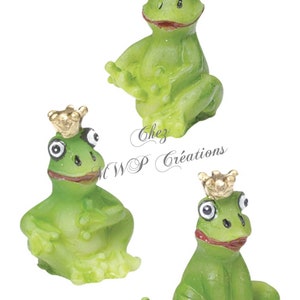 May include: Three green frog figurines wearing gold crowns. The frogs are sitting with their legs crossed and have large, black eyes.
