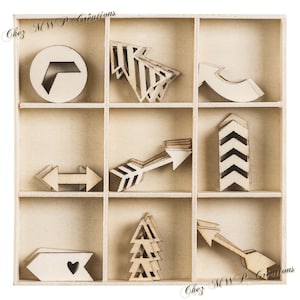 May include: A wooden box with nine compartments, each containing a different wooden arrow shape. The box is labelled "Chez MWP Creations".