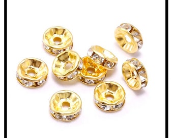 May include: Gold-toned metal bead caps with clear rhinestone accents. The bead caps are round with a raised center and a hole in the center.