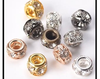 May include: Assortment of small, round, metal beads with clear rhinestone accents. The beads are in various finishes, including gold, silver, rose gold, and black.