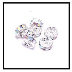 May include: Silver-toned bead caps with iridescent rhinestones. The bead caps are round and have a small hole in the center.