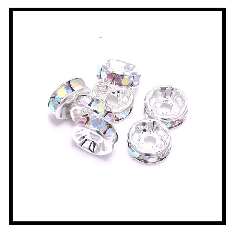 May include: Silver-toned bead caps with iridescent rhinestones. The bead caps are round and have a small hole in the center.