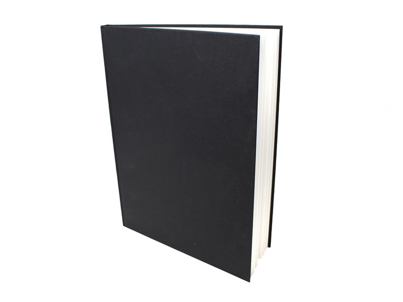 May include: A black hardback book with white pages. The book is closed and standing upright on a white background.