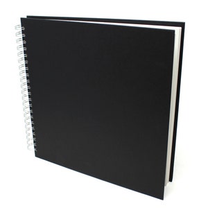 May include: A black spiral bound sketchbook with a black cover.