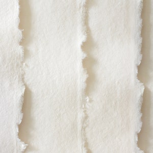 K&ouml;nnte beinhalten: Nahaufnahme von drei wei&szlig;en Papierbl&auml;ttern mit unregelm&auml;&szlig;igen, zerrissenen Kanten.