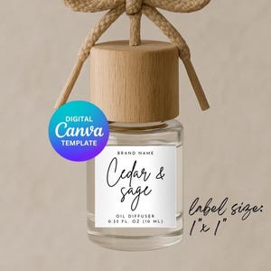 Puede incluir: Una botella de vidrio transparente con una tapa de madera y una etiqueta blanca que dice "Cedar & sage" y "Difusor de aceite 0,33 fl oz (10 ml)". El tamaño de la etiqueta es de 1" x 1".