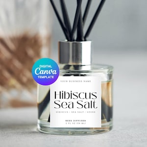 Puede incluir: Un difusor de caña de vidrio transparente con cañas negras y una tapa plateada. La etiqueta dice "Hibiscus Sea Salt" e incluye el texto "REED DIFFUSER 59 ml". Una pegatina de "Digital Canva Template" está en la esquina superior izquierda.