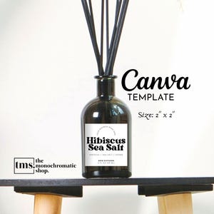 Puede incluir: Un difusor de vidrio oscuro con cañas negras, etiquetado como "Hibiscus Sea Salt". La etiqueta incluye el texto "Canva TEMPLATE" y "Size: 5 cm x 5 cm". La botella está sobre una estantería oscura con fondo blanco.