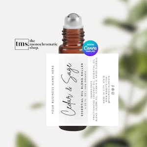 May include: A white label with black text for a 10 ml essential oil blend roller bottle. The label reads "Cedar & Sage Essential Oil Blend Roller 10 ml 100% Organic". The ingredients are listed as "Fractionated Coconut Oil, Essential Oil Blend, Jojoba Oil, Vitamin E, Dried Florals". The label also includes the business name, website, and social media handles.