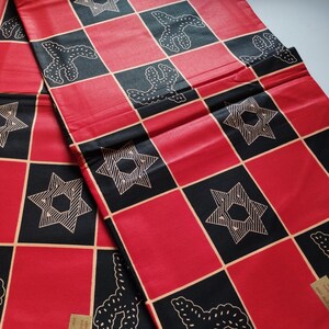 May include: Red and black fabric with a checkered pattern. The fabric features a repeating design of stars and stylized floral motifs.
