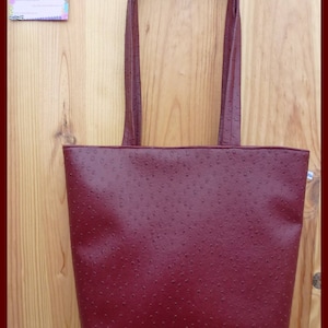 Burgunderrote Handtasche aus Straußen-Kunstleder.