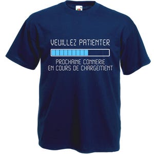 Peut inclure: Un t-shirt bleu marine avec un graphique blanc qui dit "Veuillez patienter" avec une barre de progression et le texte "Prochaine connerie en cours de chargement".