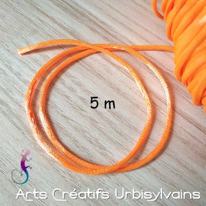 Può includere: Un rotolo da 5 metri di cordoncino arancione brillante con un leggero luccichio bianco. Il cordoncino è arrotolato ed è pronto per essere utilizzato per progetti di artigianato.