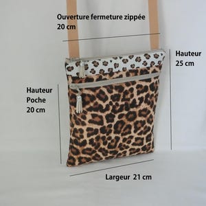 May include: A rectangular crossbody bag with a leopard print pattern. The bag has a beige strap and two zippered compartments. The bag's height is 9.8 inches, the pocket height is 7.9 inches, and the width is 8.3 inches. The zipper opening is 7.9 inches.