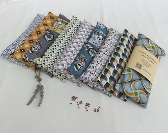 May include: A set of eight eye pillows with different geometric and patterned fabric designs. The pillows are made of fabric with a variety of colors, including blue, green, yellow, and gray. The pillows are arranged in a row, with the largest pillow at the bottom and the smallest pillow at the top. The pillows are labeled "Coussin de relaxation pour les yeux" which translates to "Relaxation pillow for the eyes".