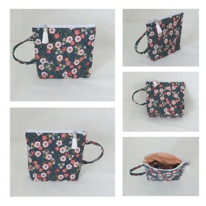 May include: A small, dark blue zippered pouch with a floral print and a white tassel. The pouch has a top handle and is shown in multiple views.
