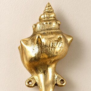 Close up of brass shell spiral hook showing hand cast spiral shell texture