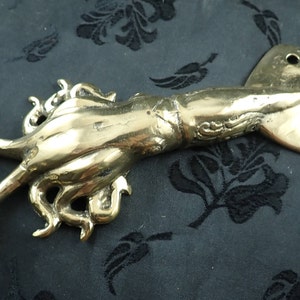 Side view brass squid wall hook showing curved tentacle hook function