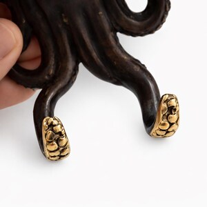 Close-up of antique brass octopus hook handcrafted marine wall decor