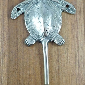 May include: Silver turtle hook with a detailed shell design and a long, slender hook. The hook is attached to the turtle's tail.