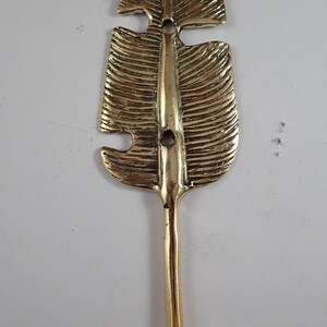 Close up of the brass ball tip hook end on a banana leaf wall hook, top angle detail shot