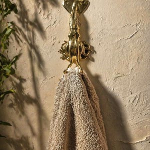 Squid wall hook used as towel hanger in coastal bathroom decor, nautical sea life wall hook styling