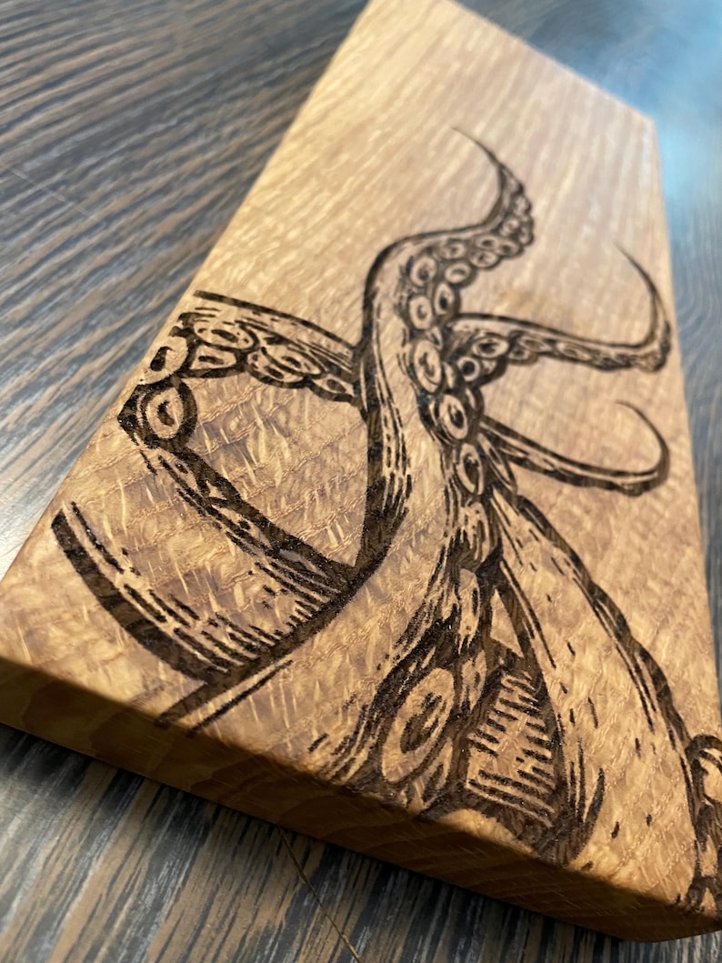 May include: A wooden cutting board with a burned-in design of an octopus tentacle.