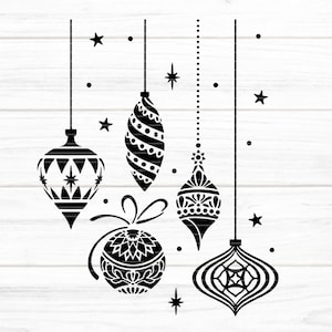 May include: Five black and white Christmas ornaments with intricate designs hanging from strings against a white woodgrain background.