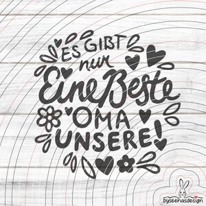 Könnte beinhalten: Schwarz-weißes Grafikdesign mit dem Text "Es gibt nur Eine Beste Oma Unsere!", umgeben von Herzen, Blumen und Blättern. Das Design befindet sich auf einem weißen Holzmaserungshintergrund.