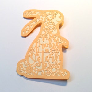 May include: A peach-colored paper Easter bunny card with a floral design and the text "Frohe Ostern" in white.