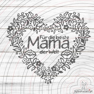May include: A heart-shaped floral design with the German text "Für die beste Mama der Welt" (For the best Mom in the world). The design features leaves, flowers, and other botanical elements. The background has a wood grain pattern.