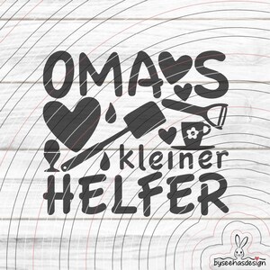 May include: A black and white graphic design featuring the text "OMA'S kleiner HELFER" and kitchen-related illustrations such as hearts, a whisk, and a teacup. The design is set against a white, wood-grain background.