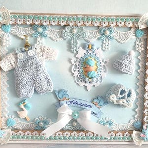 PROMO exceptionnelle    Cadre/Vitrine  bébé Garçon  (sans vitre vu les épaisseurs)avec Véritables mini layettes tricotées  pièce Unique