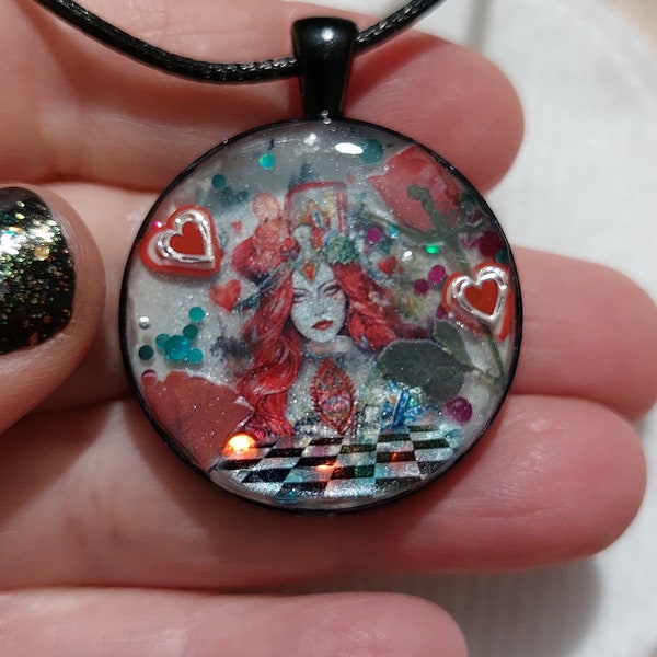 Pendentif de forme ronde avec un mini monde réalisé à la résine UV dedans .