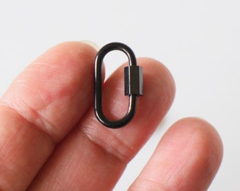 Könnte beinhalten: Schwarzer Metall-Krabbenverschluss mit silberner Oberfläche.