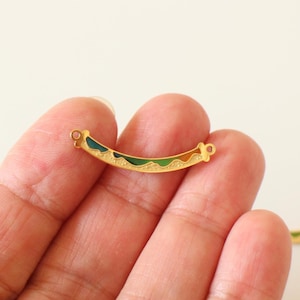 Peut inclure: Connecteur en métal doré avec un motif en émail coloré. Le connecteur a deux boucles à chaque extrémité.