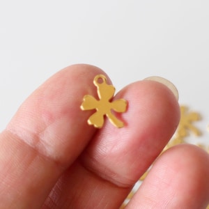 Peut inclure: Breloque en métal couleur or en forme de trèfle à quatre feuilles avec un trou en haut pour l'attacher à des bijoux ou d'autres objets artisanaux.