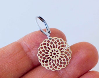 May include: A silver earring with a delicate, circular, openwork design. The design resembles a flower with intricate details.