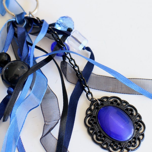 A key bag jewel oval cabochon in blue and black glass different assorted satin and muslin ribbons and various pearls Handmade
