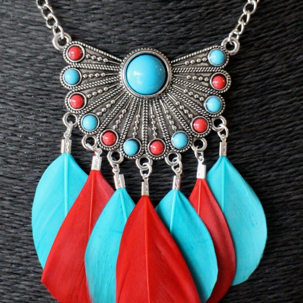 Un collier sautoir style bohème ethnique avec plumes rondes rouge et bleu et estampe à petits cabochons ronds assortis Fait-main