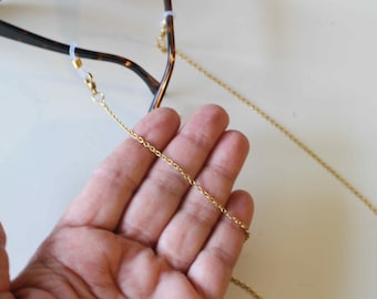 A chain for glasses in gold stainless steel with transparent silicone links in the shape of an infinity of 8 Handmade in a free gift box