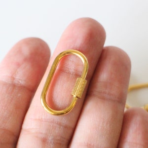 May include: Gold-toned metal oval-shaped lobster clasp with a textured, ridged bar.