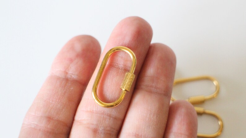 May include: Gold-toned metal oval-shaped lobster clasp with a textured, ridged bar.
