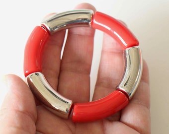 Un bracelet en perles tubes légèrement incurvées en acrylique rouge et argent fil élastique intérieur Fait-main modèle unique