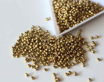 Round gold seed beads in golden glass 2 mm