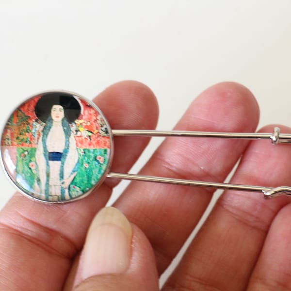 Un Broche Klimt en forme d'épingle à nourrice avec cabochon en verre rond portrait de femme multicolore Fait-main emballage cadeau offert