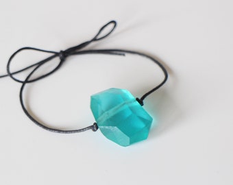 Un bracelet à nouer réglable avec perle en résine bleu et coton enduit noir Fait-main un seul disponible emballage cadeau offert