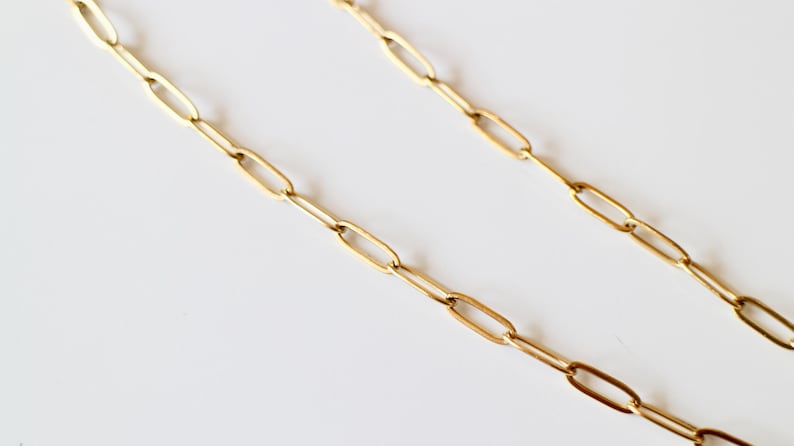 Puede incluir: Un collar de cadena en tono dorado con eslabones rectangulares alargados estilo clip. Los eslabones met&aacute;licos est&aacute;n conectados en un patr&oacute;n continuo y repetitivo, creando un dise&ntilde;o uniforme y estructurado con un acabado met&aacute;lico pulido.