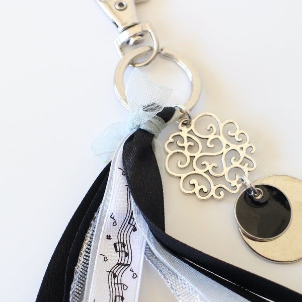 Un bijou de sac sequin émaillé noir différents rubans satin et organdi notes de musique estampe ronde ciselée arabesques Fait-main