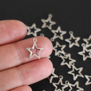 10 hollowed out star charms in silver stainless steel 15 x 13 mm